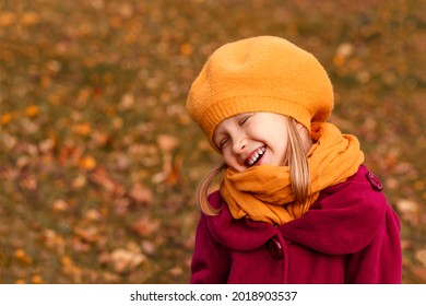 Dreamy Little Girl In A Yellow Beret And Autumn Clothes On An Autumn Background. Smiling Kid Play In Autumn Park.