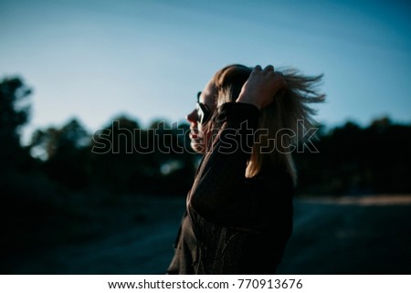 Similar – Blonde woman with black dress and sunglasses performing dance in nature with backlight