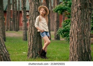 Dreamy Preteen Girl Leaning Against Tall Tree In Green Courtyard Of Country House