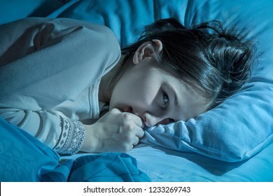 A Dreamy Romantic Thoughtful Teenager Girl At Home Bedroom Lying In Bed Late At Night Trying To Sleep, Suffering Insomnia, Sleeping Disorder Or Scared On Nightmares Looking Sad, Worried And Stressed