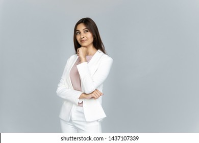 Dreamy Thoughtful Young Indian Business Woman Wearing White Suit Looking Away At Copy Space Dreaming Isolated On Grey Blank Studio Background Thinking Of Future Job Opportunity Hoping For Success