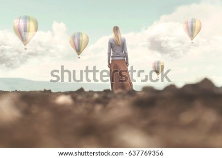 Dreamy woman looks at the hot air balloons coming down