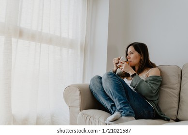 Dreamy Young Beautifu Woman Drinking Gass Cup Of Tea And Looking Through Window On Loggia At Home