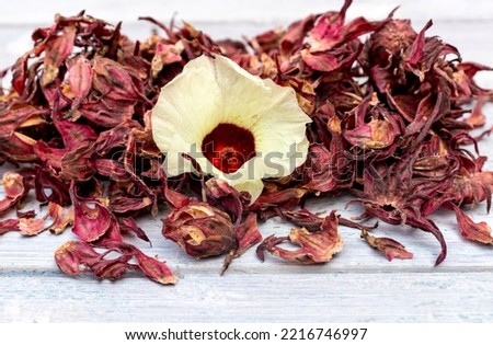 Dreid Roselle Fruit or Hibiscus Sabdariffa Fruit with Flower Isolated on White Wooden Background