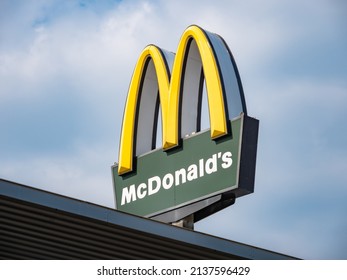 DRESDEN, GERMANY - 19. March 2022: McDonald's Logo On Top Of A Restaurant. Sign On A Signpost To Advertise For The Fast Food Company. American Franchise Business In A German City.