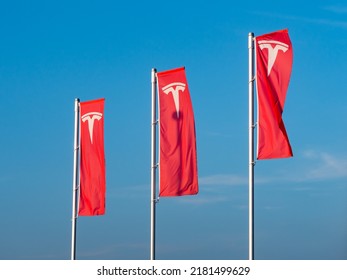 DRESDEN, GERMANY - 22. July 2022: Tesla Inc. Logo On Red Flags Fluttering In The Wind. Advertisement Of A Car Dealer. The American Automotive Company Is A Manufacturer Of Electric Vehicles.