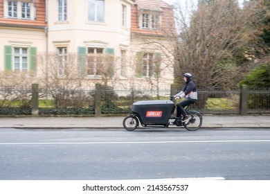 DRESDEN, GERMANY - 30. March 2022: A Gorilla Delivery Driver On A Cargo Bike. Fresh Food Is Quickly Delivered To A Customer. 