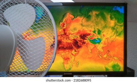 Dresden, Germany - July 21, 2022: Map Of Europe On Windy Weather Web Service Digital Map Showing Global Heatwave Of Extreme High Temperature And A Fan Trying To Cool It Down. Concept Of Global Warming