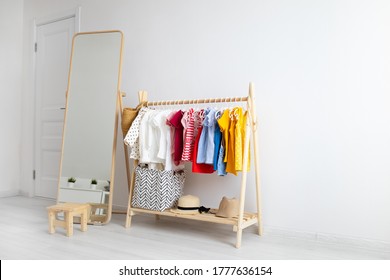 Dressing Closet With Clothes Arranged On Hangers. Colorful Wardrobe Of Newborn, Kids, Toddlers, Babies Full Of All Clothes. Montessori Wardrobe