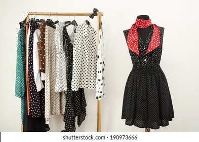 Dressing closet with polka dots clothes arranged on hangers and an outfit on a mannequin. Colorful wardrobe with polka dots clothes and accessories.   - Powered by Shutterstock