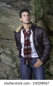 Dressing in a dark brown leather jacket, a long pattern scarf and white sweater, a handsome middle age guy is confidently looking up. / Looking Up