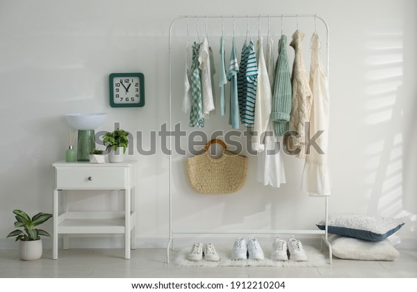 Dressing\
room interior with clothing rack and\
nightstand