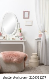 Dressing Table With Decor Near White Wall In Room