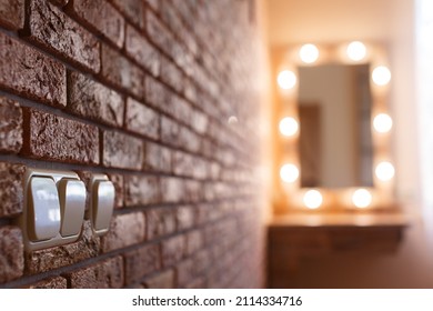 Dressing Table With Mirror And Lamps In The Bedroom On The Brown Brick Wall With Light  Switch Background With Copy Space . Detail Of The Interior Of Women's Room In The Style Of Loft And Minimalism