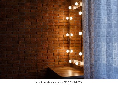 Dressing Table With Mirror And Lamps In The Bedroom On The Brown Brick Wall With Light  Switch Background With Copy Space . Detail Of The Interior Of Women's Room In The Style Of Loft And Minimalism