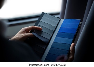 The dressmaker is choosing the fabric to cut the suit. Customers are choosing the color of the fabric in order to tailor the suit. - Powered by Shutterstock