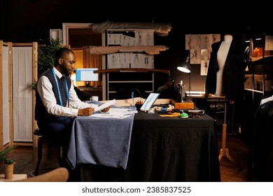 Dressmaker looking over handdrawn sketches, trying to pick best design for important event dress comissioned by rich businesswoman. Fashion designer working on bespoken garments in atelier studio - Powered by Shutterstock