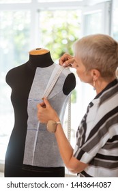 Dressmakers Dummy. Short-haired Blond Female Tailor Standing With A Pinball On Her Hand While Taking Measurements