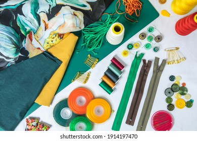 Dressmaker's Workspace. Professional Sewing Material. Table With Fabrics, Elastic, Safety Pins, Buttons, Ribbons, Zips, Threads And Needles. Top View