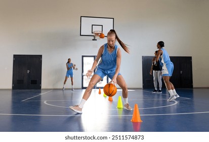 Dribbling basketball around cones, female basketball player practicing in gym. Sports, athletic, practice, training, female athlete, exercise - Powered by Shutterstock