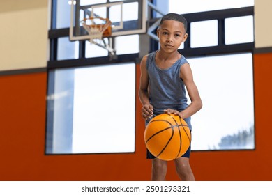 Dribbling basketball, boy practicing in school gym, focusing on skills. Sports, practice, gymnasium, training, determination, youth sports - Powered by Shutterstock