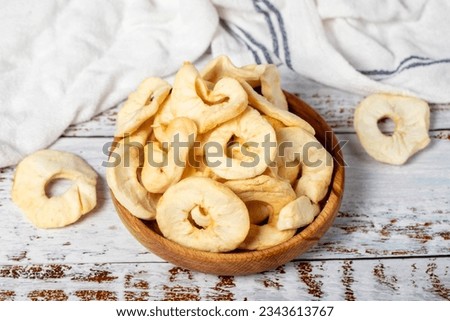 Dried apple slices in wooden bowl. Sun-dried natural apple slices on a white wood background. close up