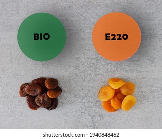 Dried apricot comparison. Apricot with preservatives (E220 Sulfur dioxide) and organic fruit without. Color difference. Dehydrated food pile.