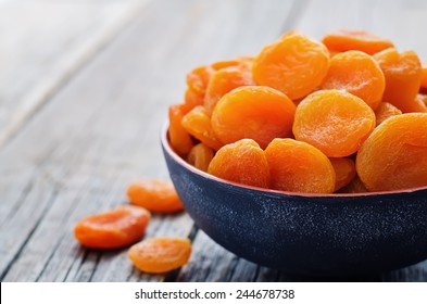 dried apricots on a dark wood background. tinting. selective focus