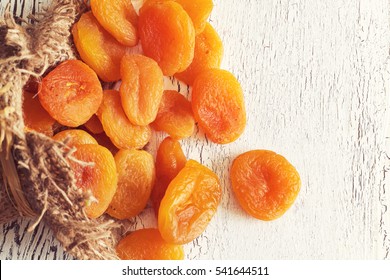 Dried apricots on white rustic wooden background. Top view with copy space