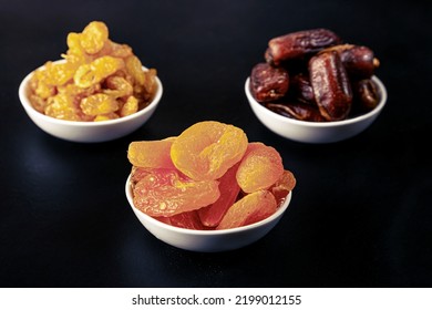 Dried Apricots, Raisins And Dates In White Masks On A Black Background