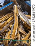 Dried cod lies on the table, the buyer tries with his hand, Bergen fish market, Hordaland, Norway.