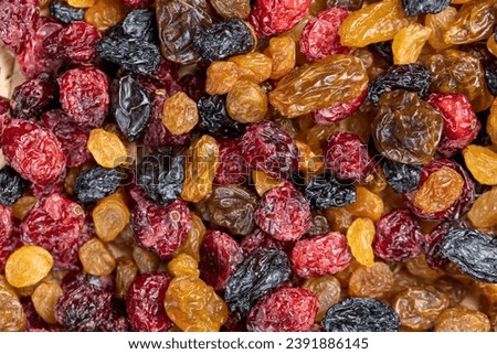dried cranberries with yellow and black raisins mixed together, a mixture of dried fruits on the table