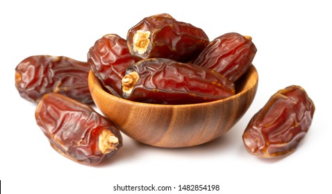 dried date palms in the wooden bowl, isolated on white background