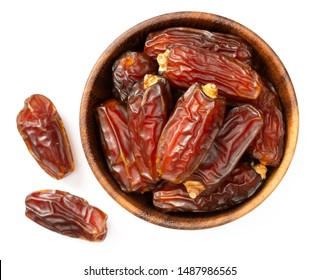 dried date palms in the wooden bowl, isolated on white background, top view
