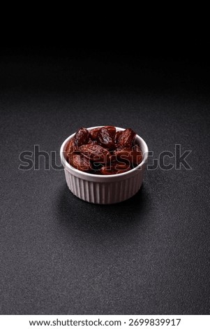 Dried dates in a ceramic plate, arabic food for the ramadan table. Dried dates as a food backdrop for your design.