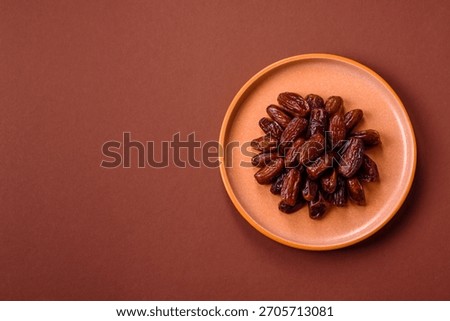Dried dates in a ceramic plate, arabic food for the ramadan table. Dried dates as a food backdrop for your design.