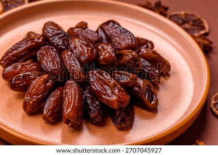 Dried dates in a ceramic plate, arabic food for the ramadan table. Dried dates as a food backdrop for your design.