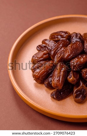 Dried dates in a ceramic plate, arabic food for the ramadan table. Dried dates as a food backdrop for your design.