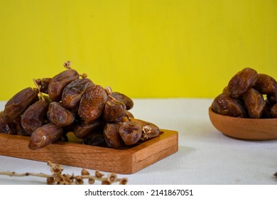 Dried dates fruit on wooden plate for ifthar ramadhan and ied fitr. whitespace background
