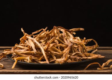 Dried Day Lily Isolated On Wooden Background