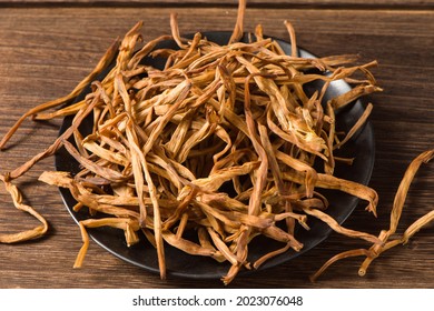 Dried Day Lily Isolated On Wooden Background