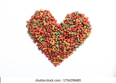 Dried Dog Food With A Shape Of Heart On White Background. Top View Colorful Grain Pet Food Banner Background With Copy Space Of Text Design. 