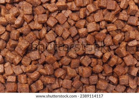 The dried feed nutriment for pet. Granulated mix of vitamins and proteins for dogs and cats. The food 
for domestic animals. Macro photography, solid fill background.