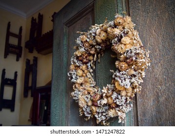 Dried Flower Summer Wreath On The Front Of A Wooden Door To A Home, With The Door Open.