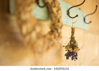 Dried flower wreath and bouquet on an antique clothes hanger on a wooden wall.  - Powered by Shutterstock