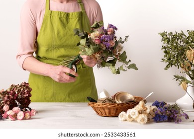 Dried flowers. Female florist arranging dried flowers into a beautiful bouquet. Sustainable floristry. Creating home decor with dried flowers. - Powered by Shutterstock