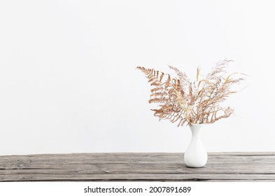 Dried Flowers In Vase On Wooden Table On White Background