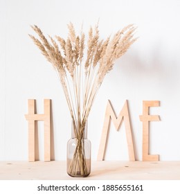 Dried Flowers And Wooden Letters Home On The Background Of A Light Wall In The Style Of Minimalism