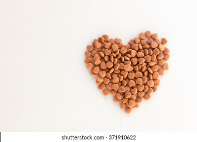 Dried Food For Dog Puppy, With A Shape Of Heart On White Background