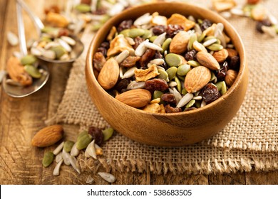 Dried Fruit And Nuts Trail Mix With Almonds, Raisins, Seeds And Apples In A Wooden Bowl